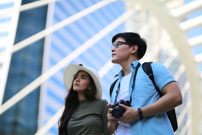 Low angle view of young couple looking up