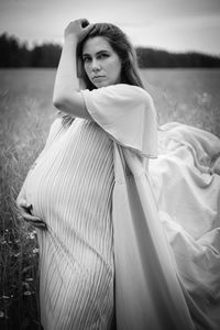 Young pregnant woman with long hair and dress in the nature. maternity. black and white photo.