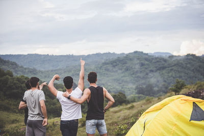 Rear view of people standing on mountain road