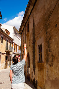 Rear view of woman standing in front of building