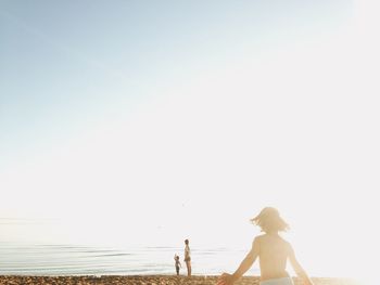 Family enjoying at beach on sunny day