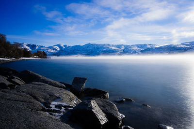 Scenic view of sea and mountains against sky