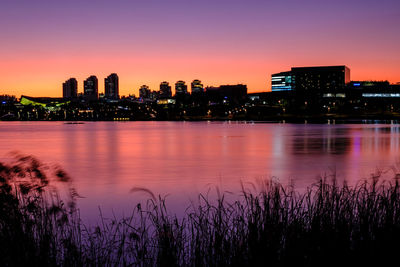 Reflection of illuminated city at sunset