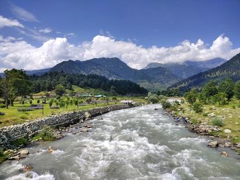 Scenic view of river amidst mountains against sky