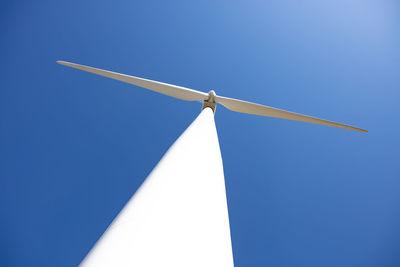 Wind turbine against blue sky with minimal sun flare