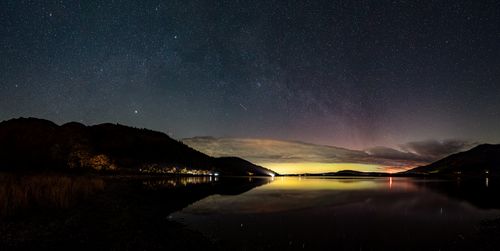 Scenic view of lake against sky at night