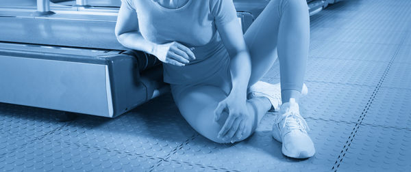 Low section of woman sitting on escalator