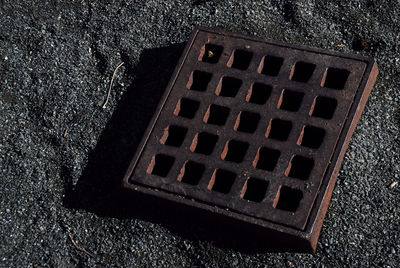 High angle view of manhole on metal grate