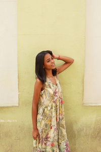 Young woman standing against wall