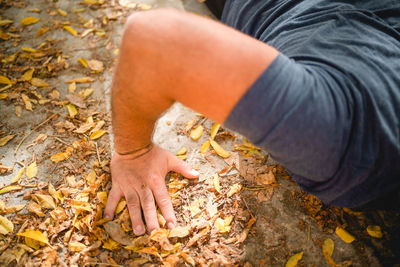 High angle view of man hand on rock