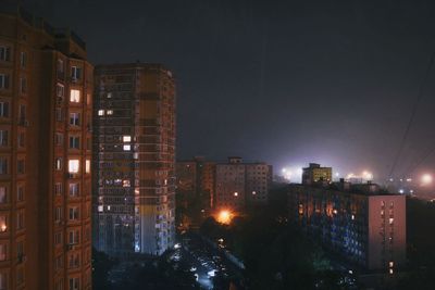 Illuminated buildings against sky at night