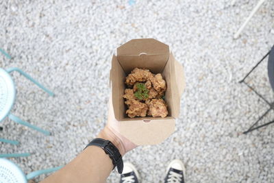 Low section of person holding ice cream on street