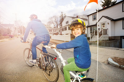 Portrait of son riding bicycle with father