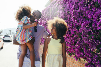 Happy girl looking at sister kissing father