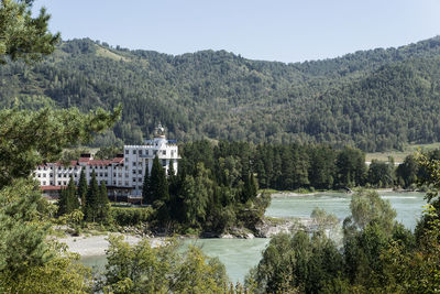 River amidst trees and buildings against sky