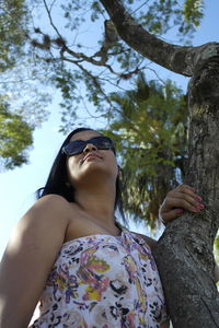 Low angle view of woman looking at tree