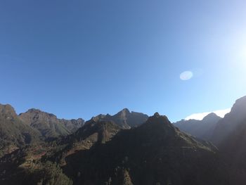 Scenic view of mountains against clear blue sky