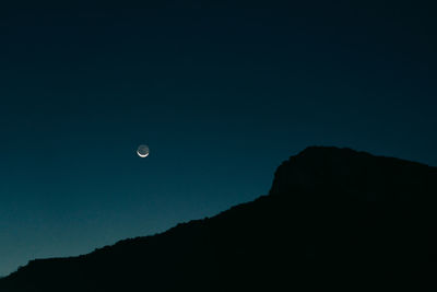 Low angle view of silhouette mountain against sky at night