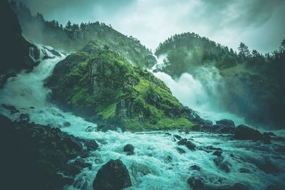 Scenic view of waterfall against sky