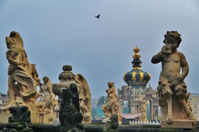Low angle view of baroque statues against sky