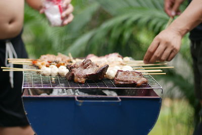 Person preparing food on barbecue grill