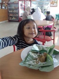 Portrait of woman sitting at restaurant table