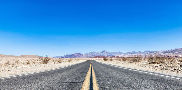 Empty road along countryside landscape