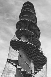 Low angle view of modern building against cloudy sky