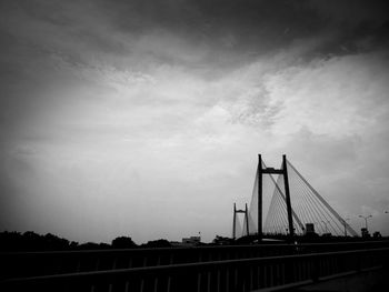 Suspension bridge over river against sky