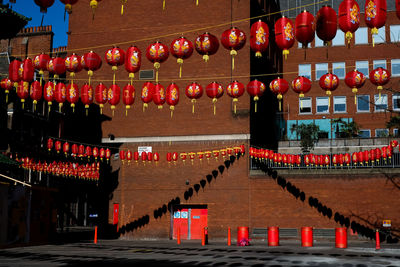 Illuminated red lanterns hanging by building