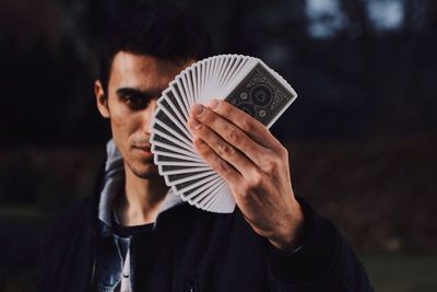 Portrait of man holding cards