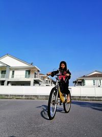 Portrait of man riding motorcycle against clear blue sky