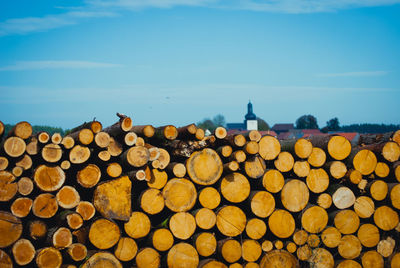 Stack of logs against sky