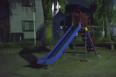 Empty playground against trees in park