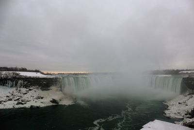 Scenic view of waterfall against sky during winter