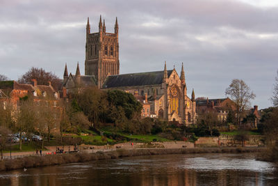 Buildingcathedral at waterfront against cloudy sky