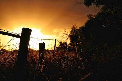 Fence against sky during sunset