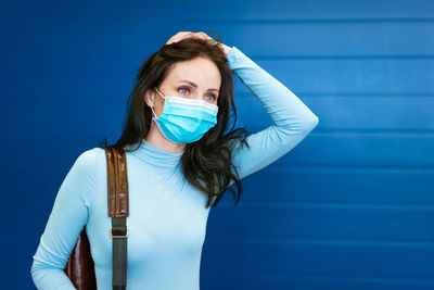 Beautiful woman with a medical mask on her face with a backpack on her back on