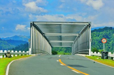 Road by mountain against sky