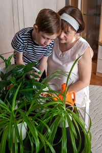 High angle view of boy holding potted plant