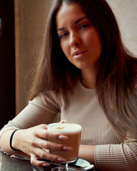 Portrait of a young woman drinking coffee