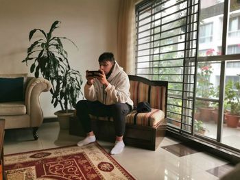 Young man sitting on sofa at home 