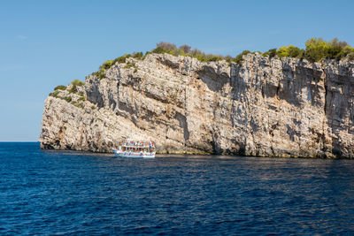 Scenic view of sea by cliff against sky