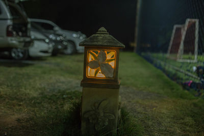 Close-up of illuminated sign on field at night