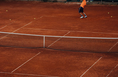 Male tennis player training serve on tennis court