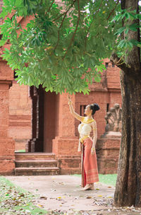 Full length of woman standing by building