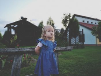 Cute girl standing against building