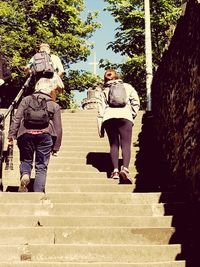 Rear view of people walking on staircase