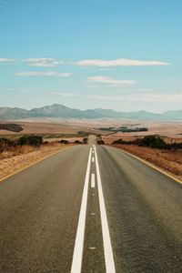 Road passing through landscape against sky