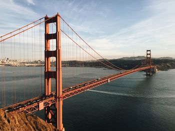 View of suspension bridge against cloudy sky